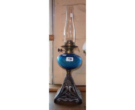 A Victorian table oil lamp with ribbed blue glass reservoir and cast iron base