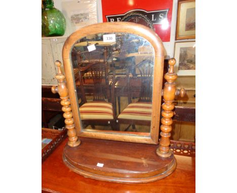 A Victorian mahogany framed platform dressing table mirror with arched plate, flanking bobbin turned supports and shaped base