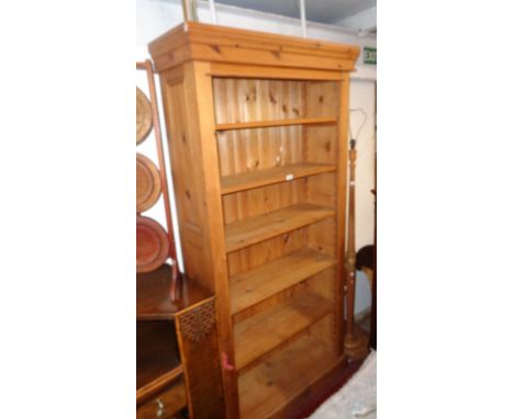 A 3' 4" waxed pine six shelf open bookcase with five adjustable shelves, moulded top and panelled sides