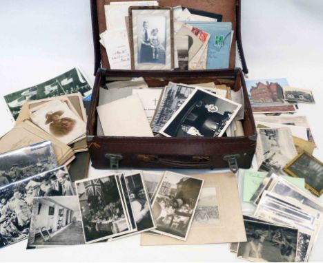 An old vintage suitcase containing a collection of early to mid 20th Century photographic ephemera including military, family