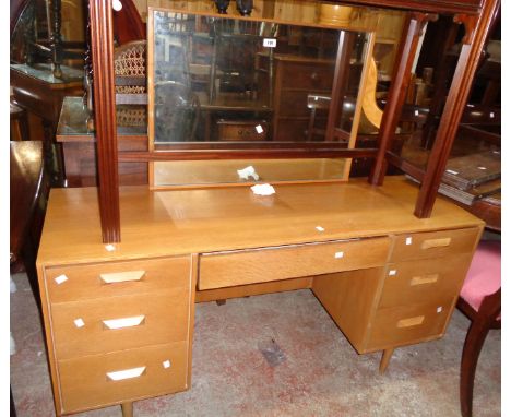 A 4' 6" vintage Stag polished light oak kneehole dressing table with oblong mirror, blind frieze drawer and six flanking draw