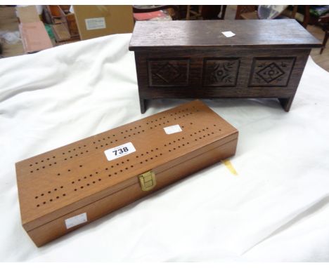 A boxed set of dominoes with cribbage board to top and a coffer style box