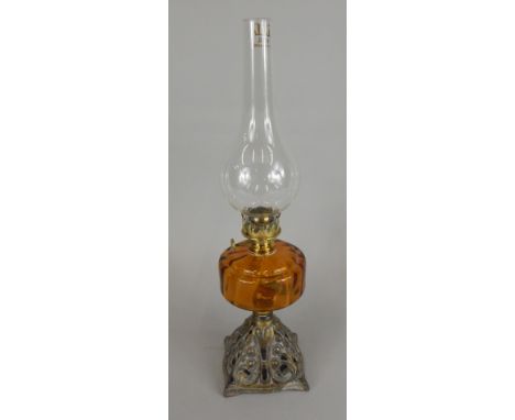 A Victorian Art Nouveau style lamp base, with amber tinted red glass reservoir, the cast iron base decorated in gilt with flo