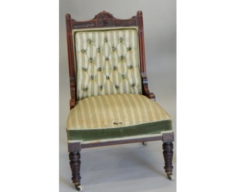 A Victorian walnut nursing chair, with a carved frame, button padded back, and padded seat on turned legs, with ceramic casto