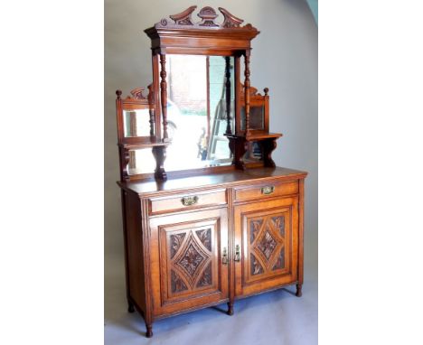 A late Victorian oak sideboard, the raised back with five bevelled mirror plates, turned supports, the base with two frieze d