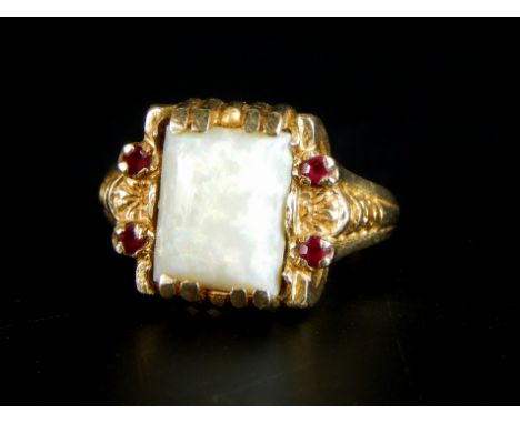 An opal ring, with rectangular stone, set in yellow metal, with rubies, the mount stamped 10K