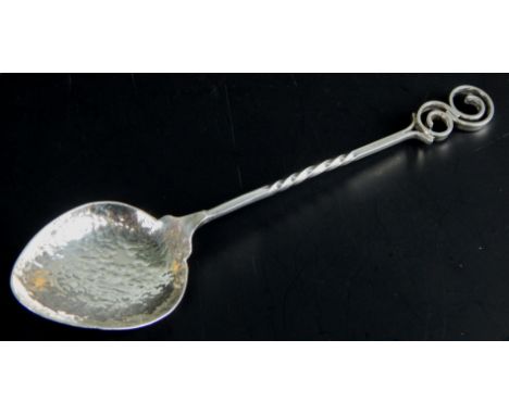 A Scandinavian white metal spoon, with hammered bowl, twisted handle, and 'C' scroll finial, marked Johnsen