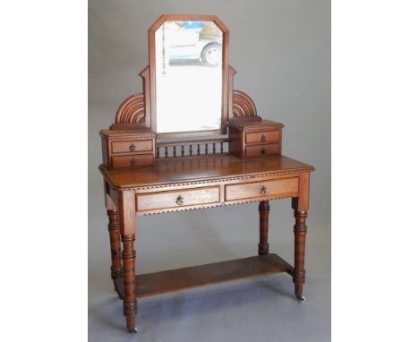 A Victorian pitch pine dressing table, with a raised mirror back, on shaped supports, with two trinket drawers, the base with