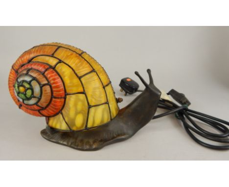 A modern bronze effect lamp base, modelled in the form of a snail with a Tiffany style stained glass shell.