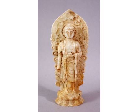 A 19TH / 20TH CENTURY CHINESE CARVED WHITE JADE / SOAPSTONE FIGURE OF A DEITY / BUDDHA, stood upon a lotus base, holding a ve