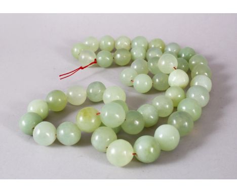 A SET OF CHINESE CARVED CELADON JADE BEAD NECKLACE, comprising 49 carved beads of varying size.