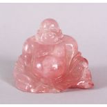 A CHINESE CARVED ROSE QUARTS FIGURE OF BUDDHA, in a reclined position with the usual humorous