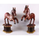 A LARGE PAIR OF CHINESE TANG STYLE CARVED WOODEN HORSE FIGURES, both slotted upon separate