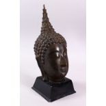 A THAI BRONZE FIGURE OF A HEAD, upon a fitted stand, 36cm high