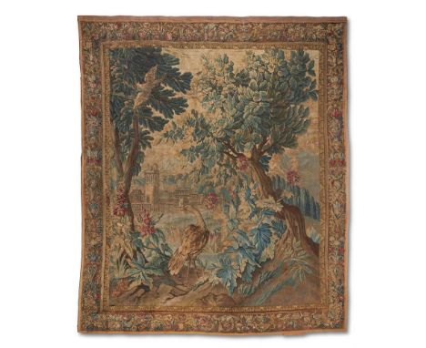 A FRENCH VERDURE TAPESTRY  EARLY 18TH CENTURY  With birds amongst trees and bushes, within an associated border of flower dra