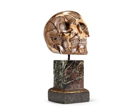 A MADAGASCAN CARVED SEPTARIAN NODULE SKULL  20TH CENTURY  The skull set on an earlier French marble base with gilt bronze ban