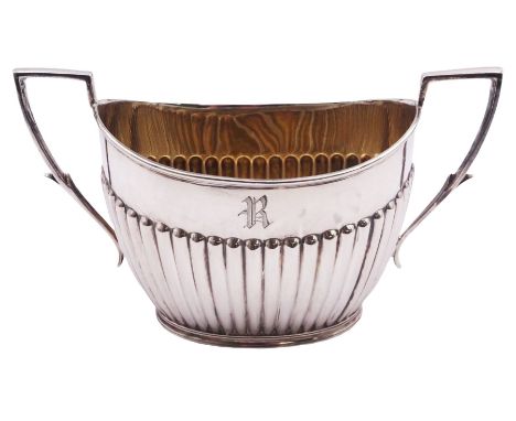 Late Victorian silver twin handled sucrier, of oval part fluted form with engraved initial and twin flat capped scroll handle