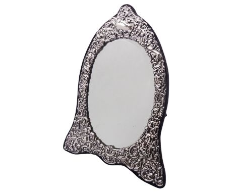 Modern silver mounted dressing table mirror of arched form, the oval bevelled mirror plate within a silver surround embossed 