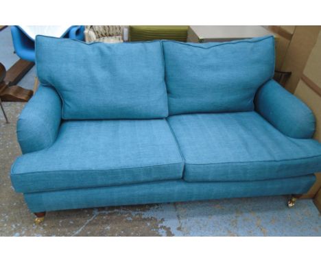 SOFA, Howard style, two seater, with turquoise upholstery on short turned front supports with brass cappings and castors, 170