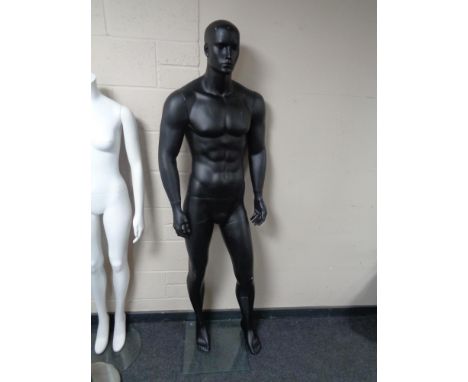 A male mannequin on stand (black). 