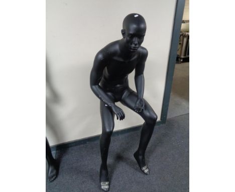 A male mannequin, no stand, seated (black). 