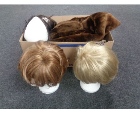Three mannequin heads with wigs together with a box containing a simulated fur coat and a fur scarf.   