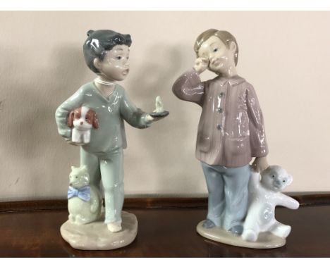 A Nao figure, boy holding puppy and candle, together with a further Nao figure, boy with teddy bear.  