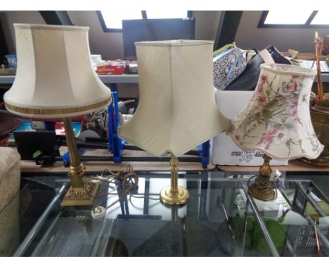 A brass Corinthian column table lamp with shade, together with two further brass table lamps with shades.  