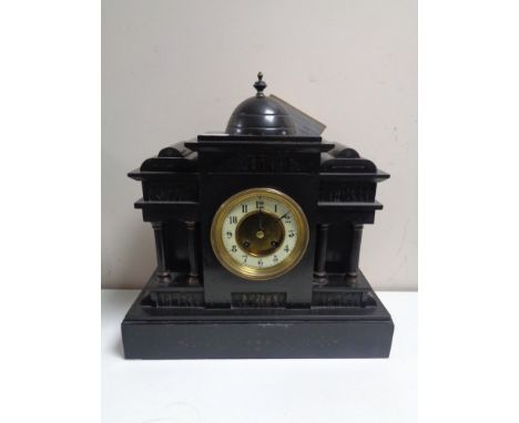 A 19th century German black slate half hour striking mantel clock with brass and enamel dial and key