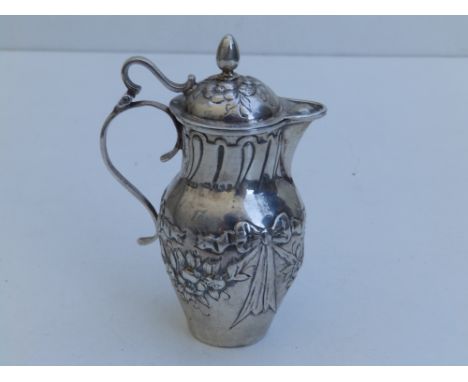 A small silver lidded jug, embossed floral swags to sides - London import marks for 1902,  3.7" high.