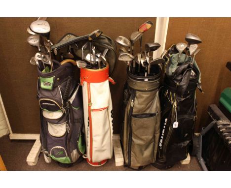 Four golf bags and collection of golf clubs including Slazenger, Dunlop, etc.