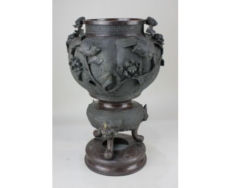 A Japanese bronze vase, circular fluted waisted form, cast with garden birds and flowers, raised on three scroll feet on circ