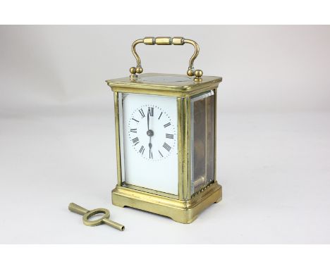 A brass carriage clock with white enamel dial and Roman numerals, 14cm high