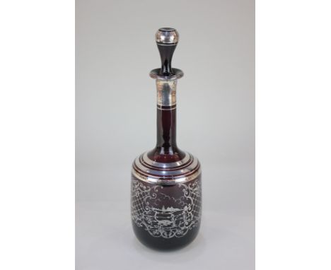 An amethyst glass decanter with silvered design of a lakeside scene, with long neck and matching stopper, 33.5cm high