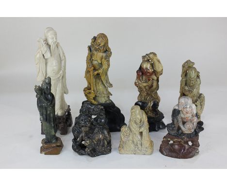 A Chinese green jade carved figure of a woman holding a lotus flower, together with seven other Chinese carved hardstone figu