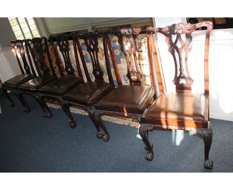 A set of six Chippendale style mahogany dining chairs with pierced ribbon scrolling foliate backs, drop-in seats, on carved c