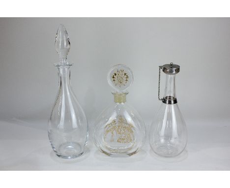 A Chichester Cathedral etched glass decanter, a Winston Churchill commemorative decanter, and another plain glass decanter wi