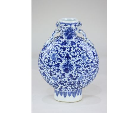 A Chinese pottery blue and white moon flask with dragon lugs and all-over floral design, 26cm high