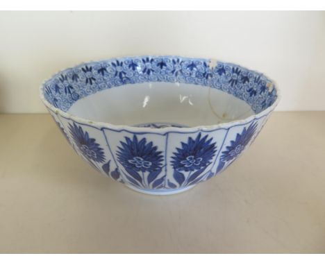 A 17th century Chinese blue and white Kangxi period porcelain bowl decorated with panels of stylised flowers, with a scroll i