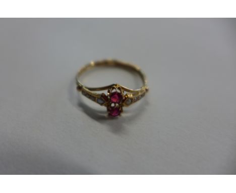 A yellow metal dress ring with pearls, ruby coloured stones, size K, approx 0.8 grams, usage marks 