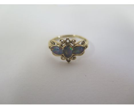 A 9ct ring set with three oval opal type stones with pierced setting, size O, approx 2.1 grams, in good condition 