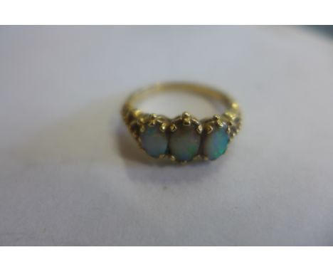 A 9ct gold three stone opal ring, size Q, approx 3.3 grams, some usage marks 