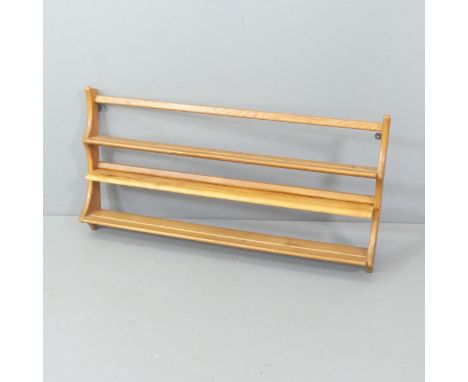 ERCOL - A mid-century elm hanging plate rack, with gold maker's label. 97x50x13cm. Additional shelf has been attached to one 