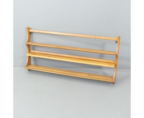 ERCOL - A mid-century elm hanging plate rack, with gold maker's label. 97x50x13cm. Additional shelf has been attached to one 