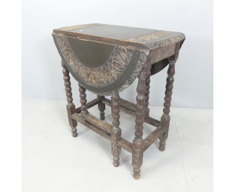 An early 20th century ebonised gate-leg table, with carved decoration and bobbin-turned legs. 66x73x31cm (opening to 84cm). 