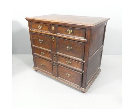 An antique joined oak Jacobean style chest of four long drawers, raised on stile legs. 95x82x55cm.This item is of mixed age. 