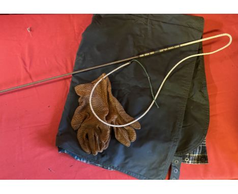 Waterproof driving apron; pigskin driving gloves and a dark brown driving whip with white metal handle.