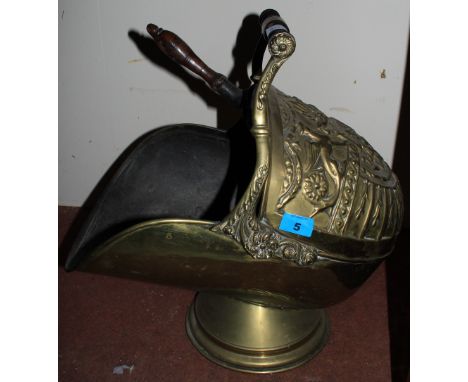 A brass embossed helmet coal scuttle with irons
