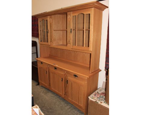 A light oak finished dresser with Art-Nouveau style decoration. 64" wide