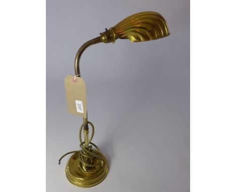 An adjustable desk lamp having a shell form shade, 71cm fully erect